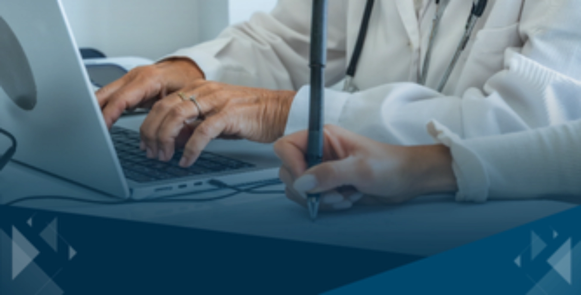 Healthcare professionals working together on a laptop and writing notes